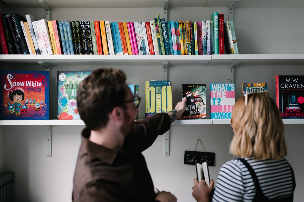 Colleagues browsing a bookshelf.